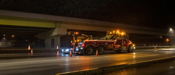 Tow truck in the rain under an overpass