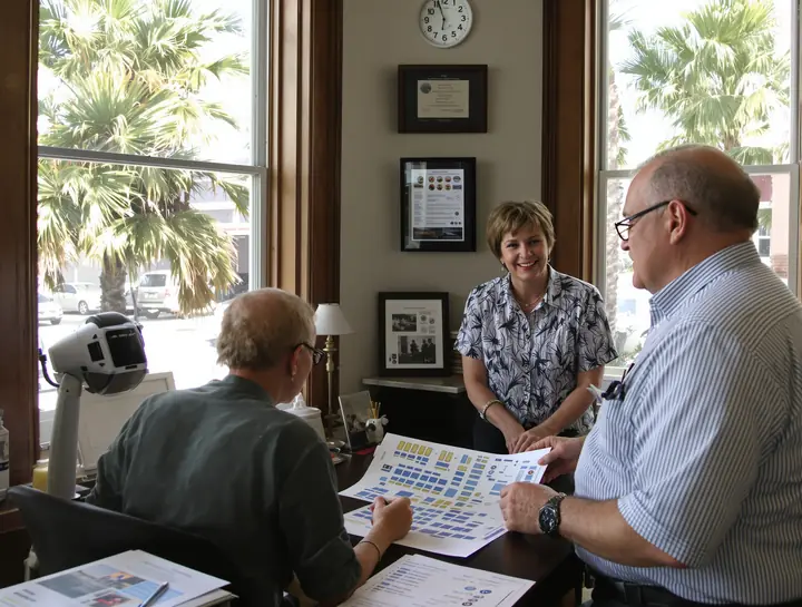 Our agent going over a ship deck plan with a couple in the Galveston office
