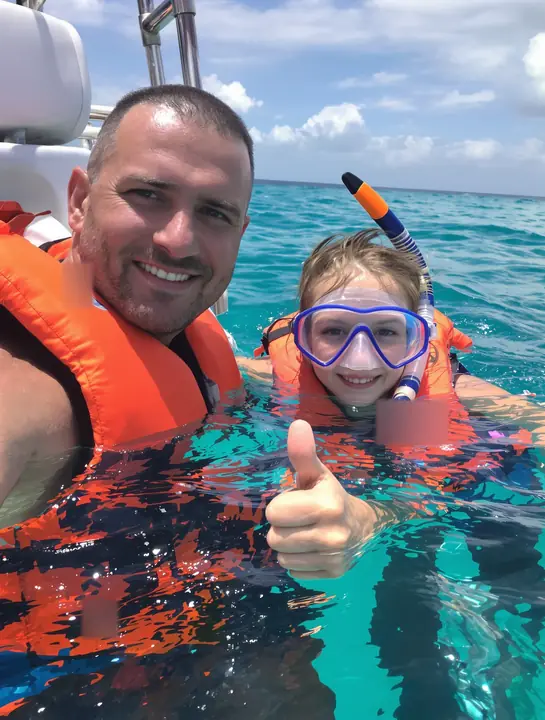 A dad and daughter snorkeling in Cozumel