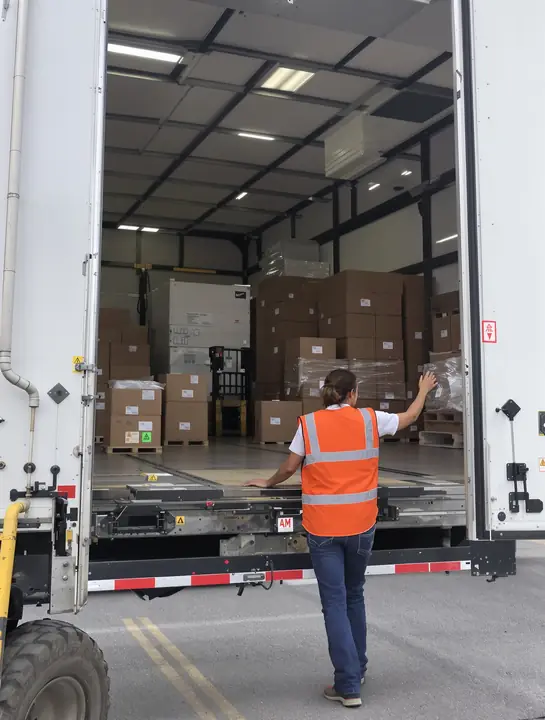 A driver closing the trailer doors at a loading dock