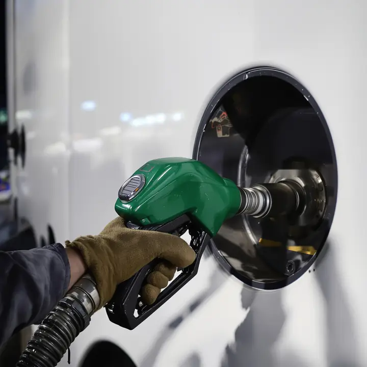 A driver fueling his tractor at night