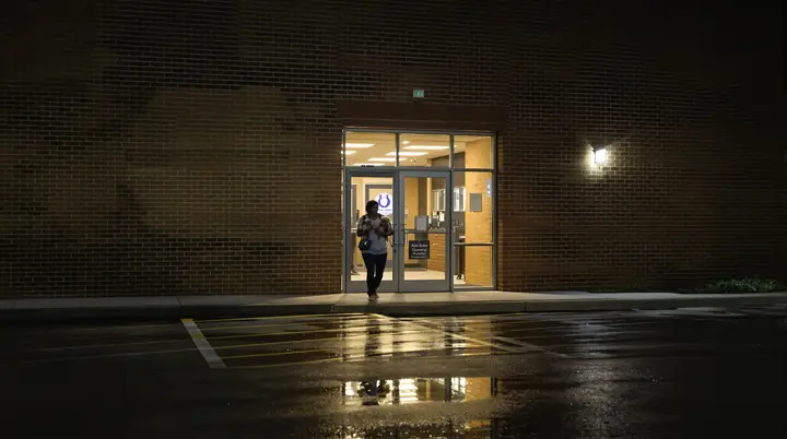 Hospital entrance at night with a wet parking lot