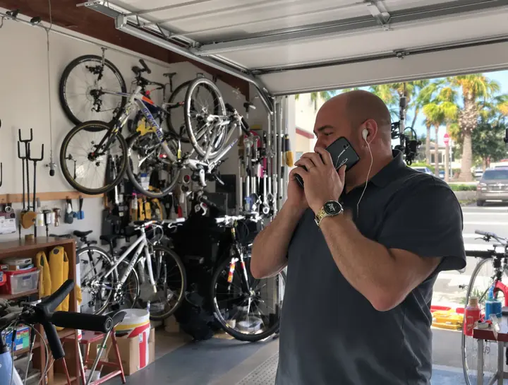 Dunedin bike shop owner answering his business line on the phone app