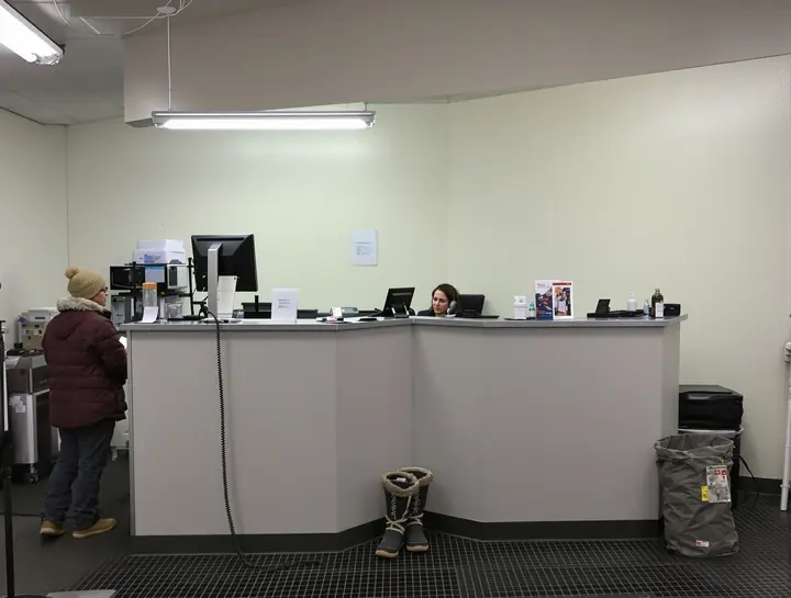 A service writer on the phone with a repair order in hand