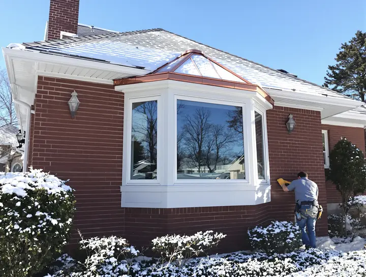 New bay window on a brick Cape Cod in Monona after the first snow