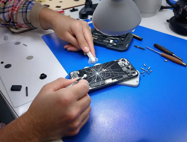 Lifting a cracked screen off with a suction cup at the repair bench